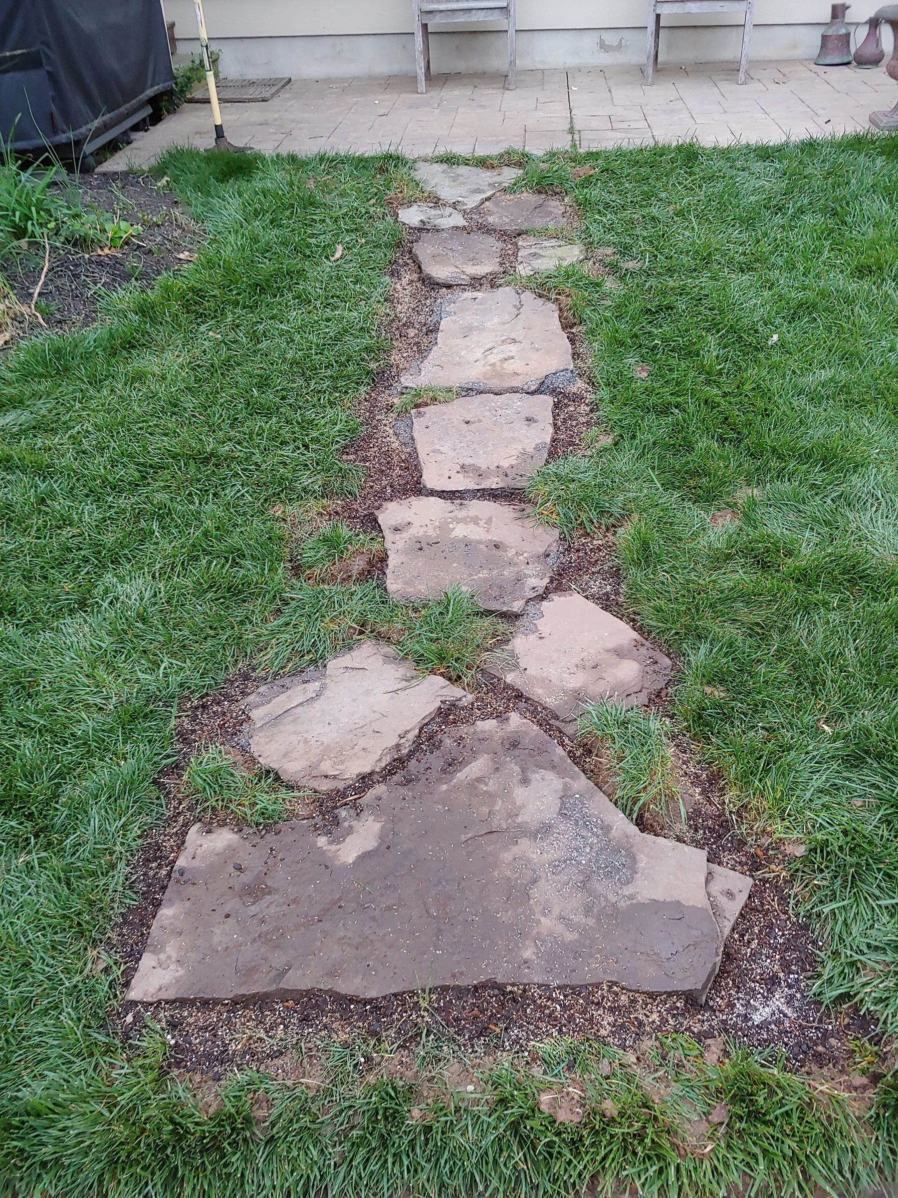 Stone path being installed and leveled in a lawn